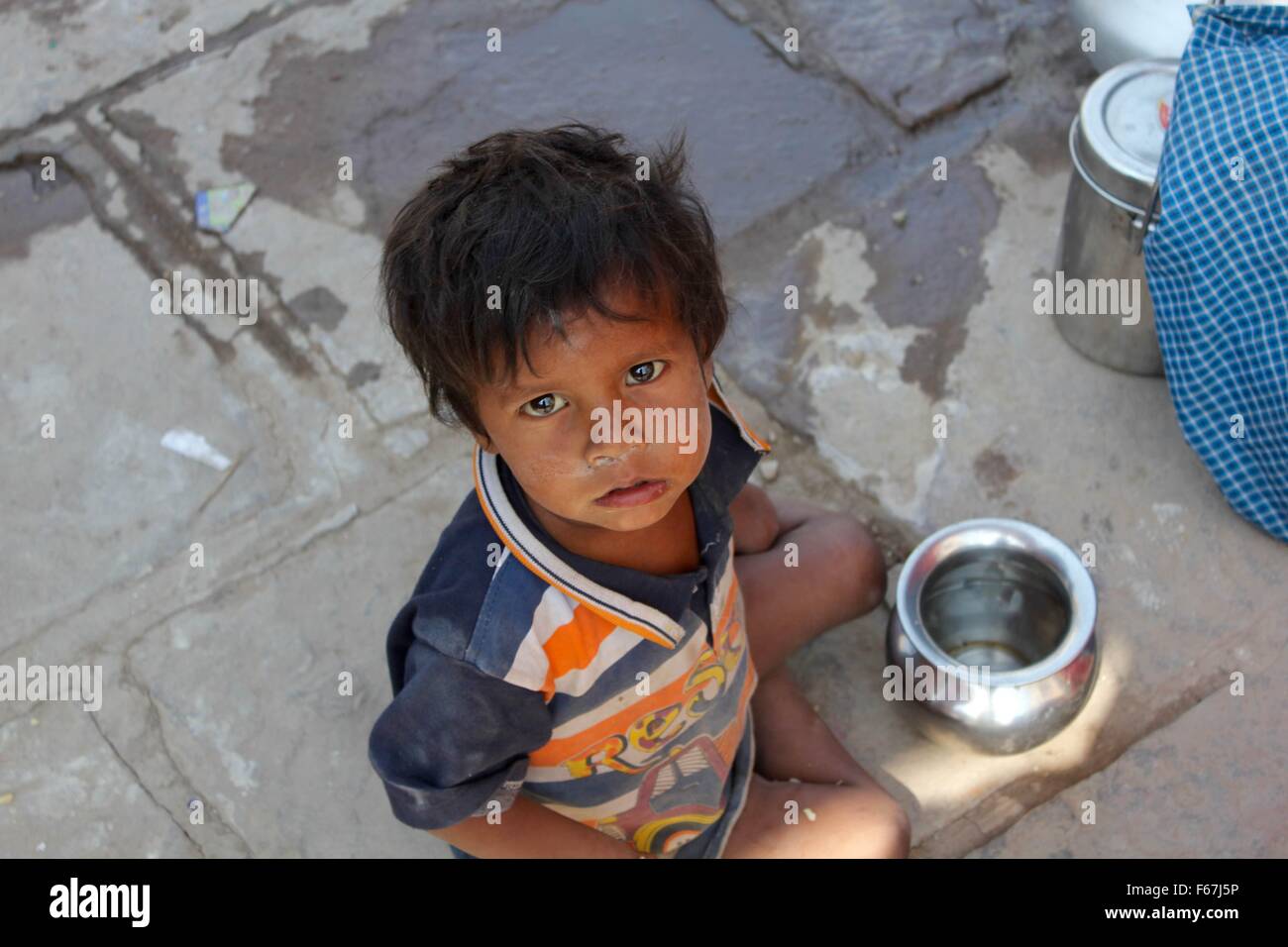 A small child in India plays with his fresh drinking water Stock Photo