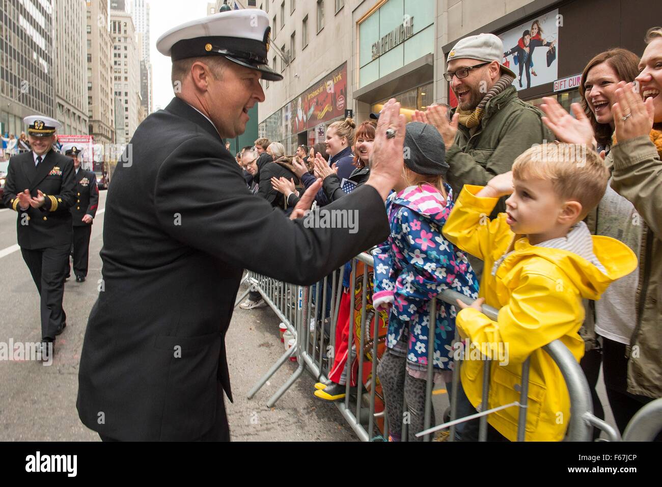 The U.S. Navy Sailors from the amphibious transport dock ship USS New York greet people gathered for the annual Veterans Day parade during Veterans Week November 11, 2015 in New York City, NY. Stock Photo