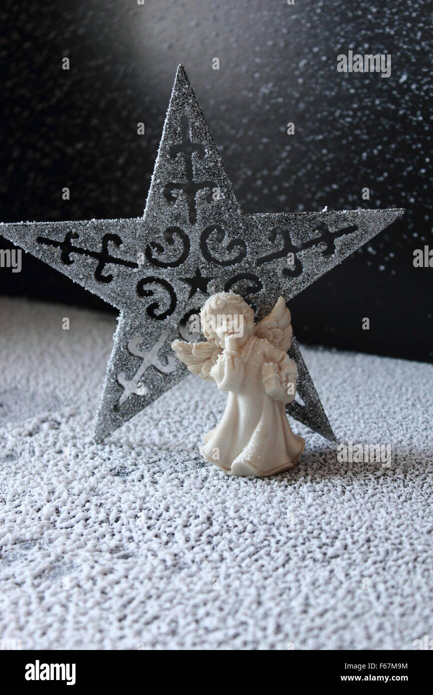 Simple composition with angel and star on the snow. Stock Photo