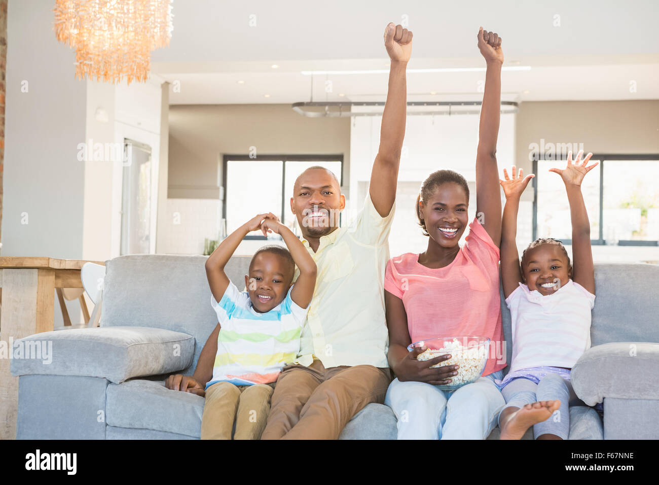 Happy family watching television eating popcorn Stock Photo