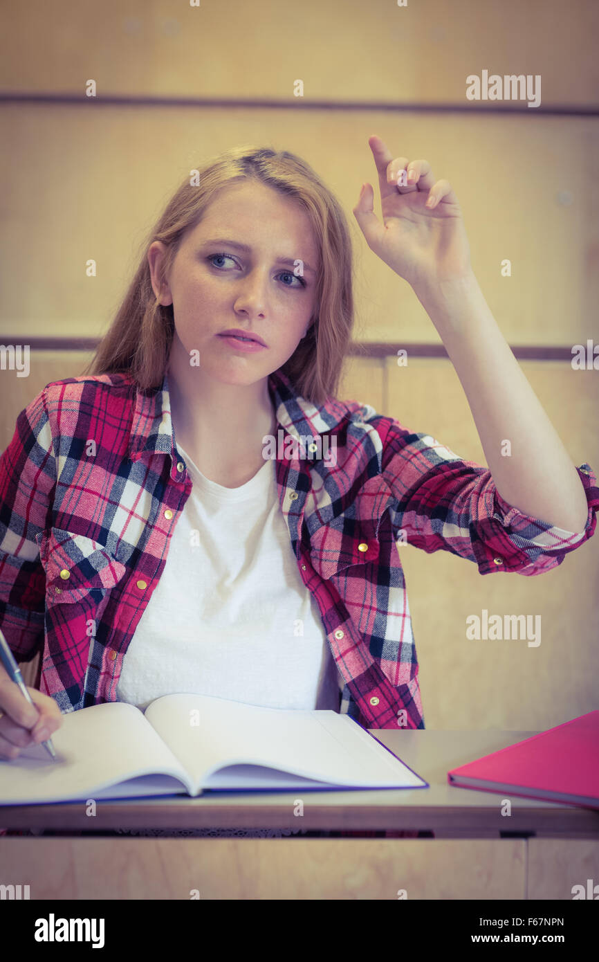 Unsure student raising the hand during class Stock Photo