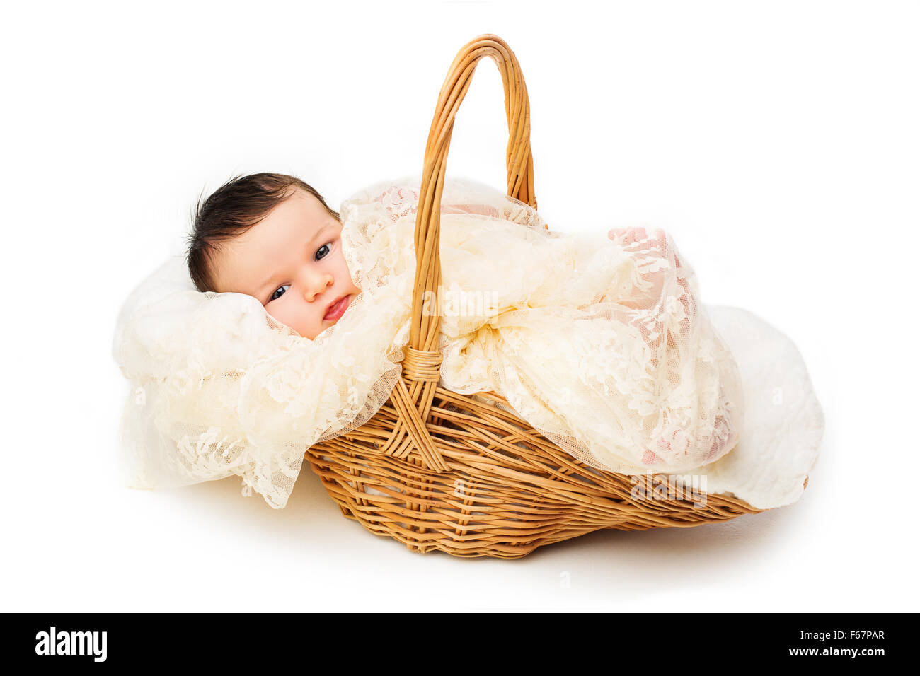 Newborn baby smiling in a wicker basket Stock Photo