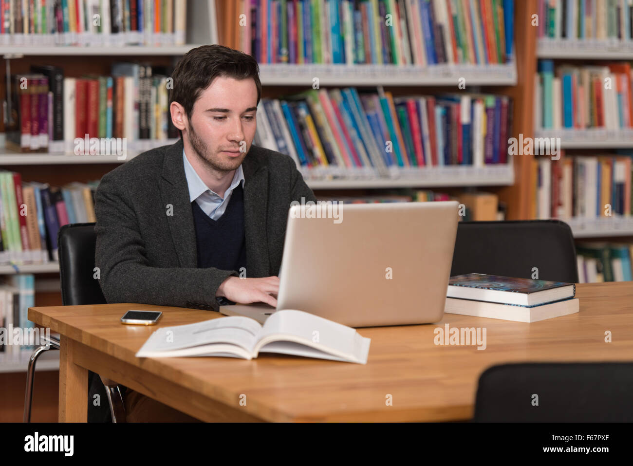 Guy In Library In The Library - Handsome Male Student With Laptop And Books Working In ...