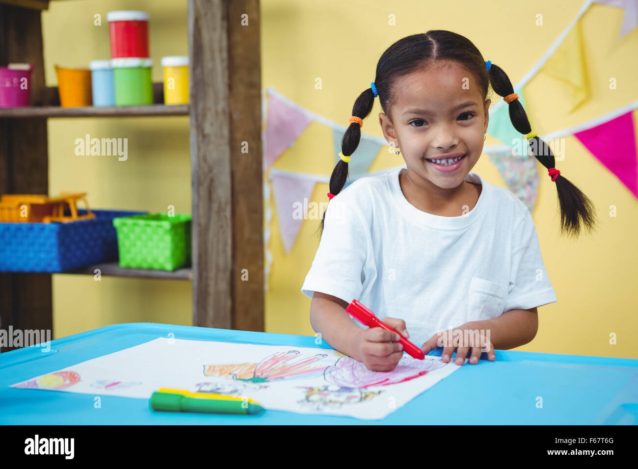 Smiling girl drawing in her colouring book Stock Photo