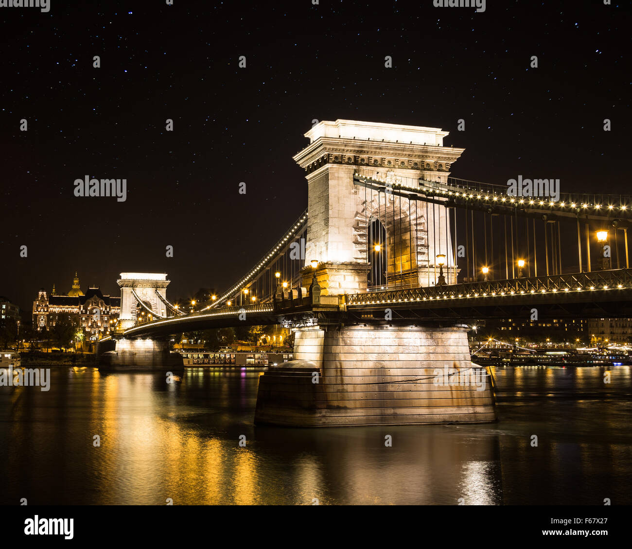 The Szechenyi Chain Bridge at night. There are stars in the sky and ...