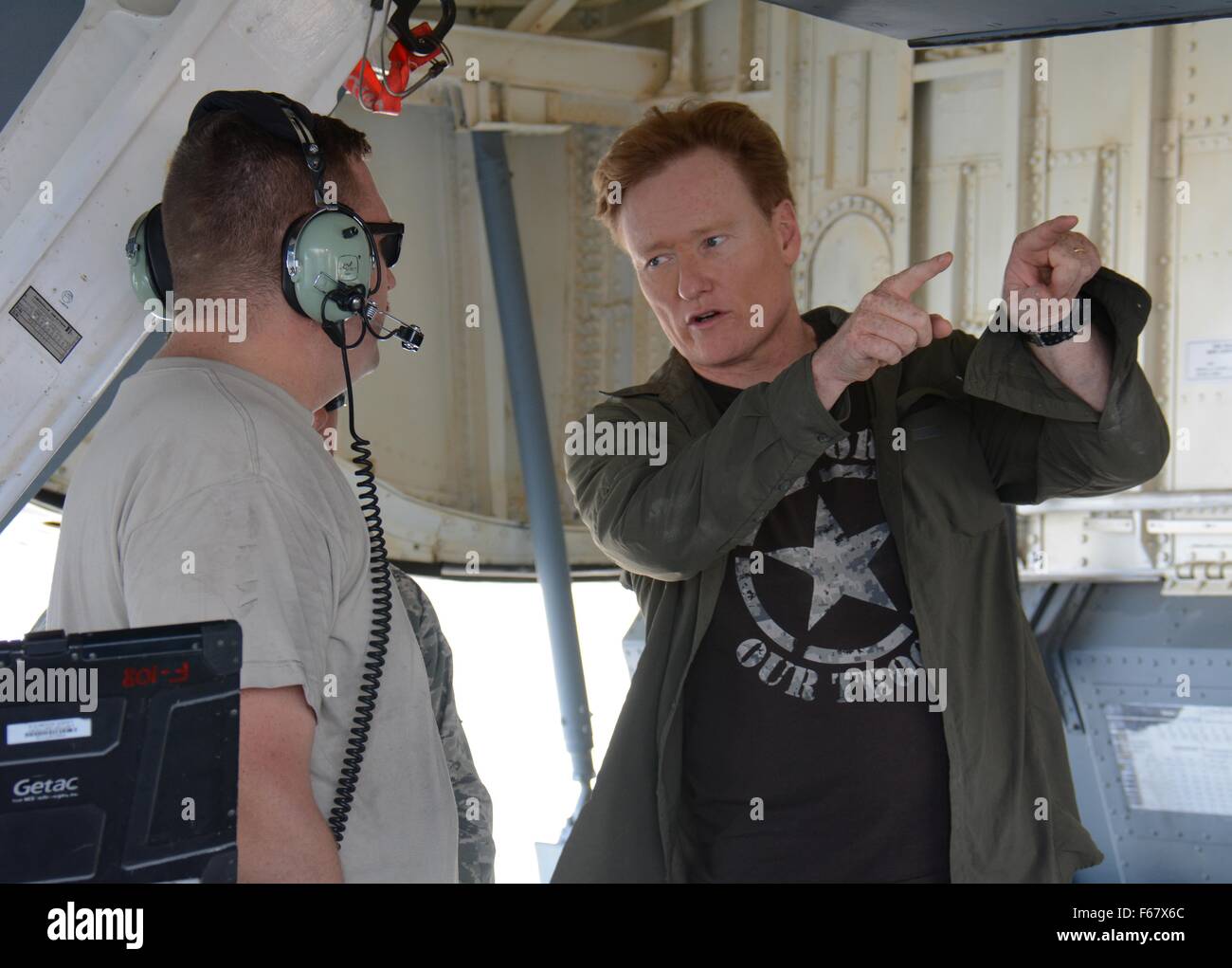 Late night talk show host and comedian Conan O'Brien talks with a U.S. airmen on the flight line during a visit to the base November 4, 2015 at Al Udeid Air Base, Qatar. O'Brien visited the airbase to entertain service members stationed overseas. Stock Photo