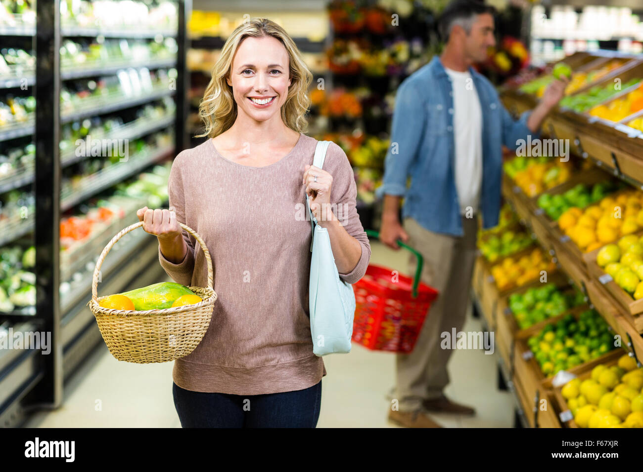 Pretty blonde woman holding vegetables basket Stock Photo - Alamy