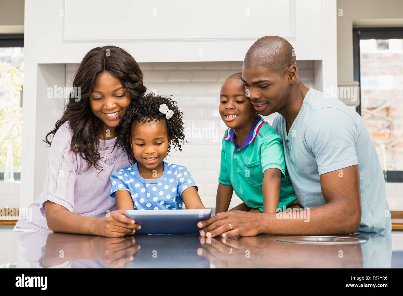 Happy family using tablet Stock Photo - Alamy