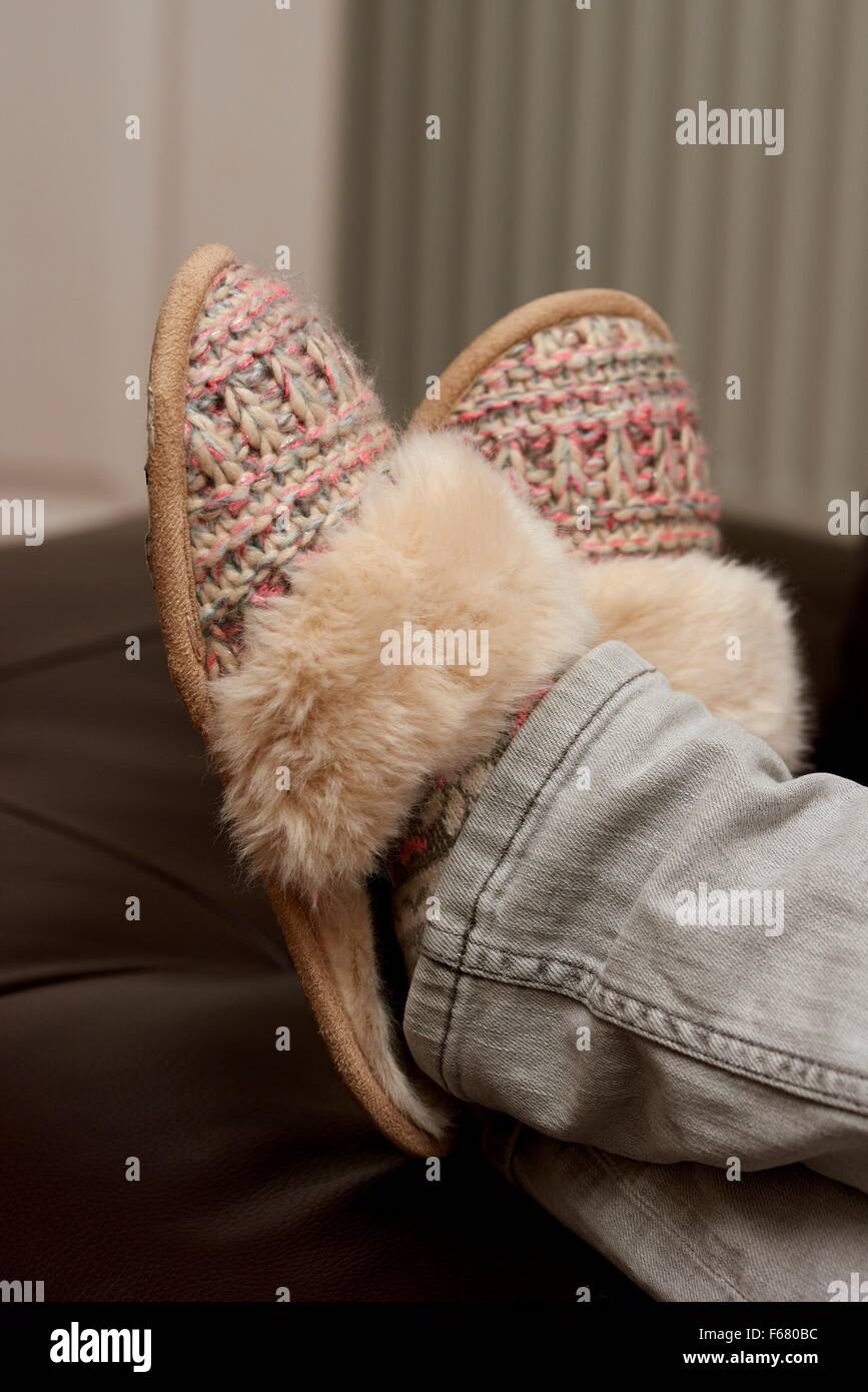 A woman relaxing with her feet up wearing slippers England UK Stock Photo