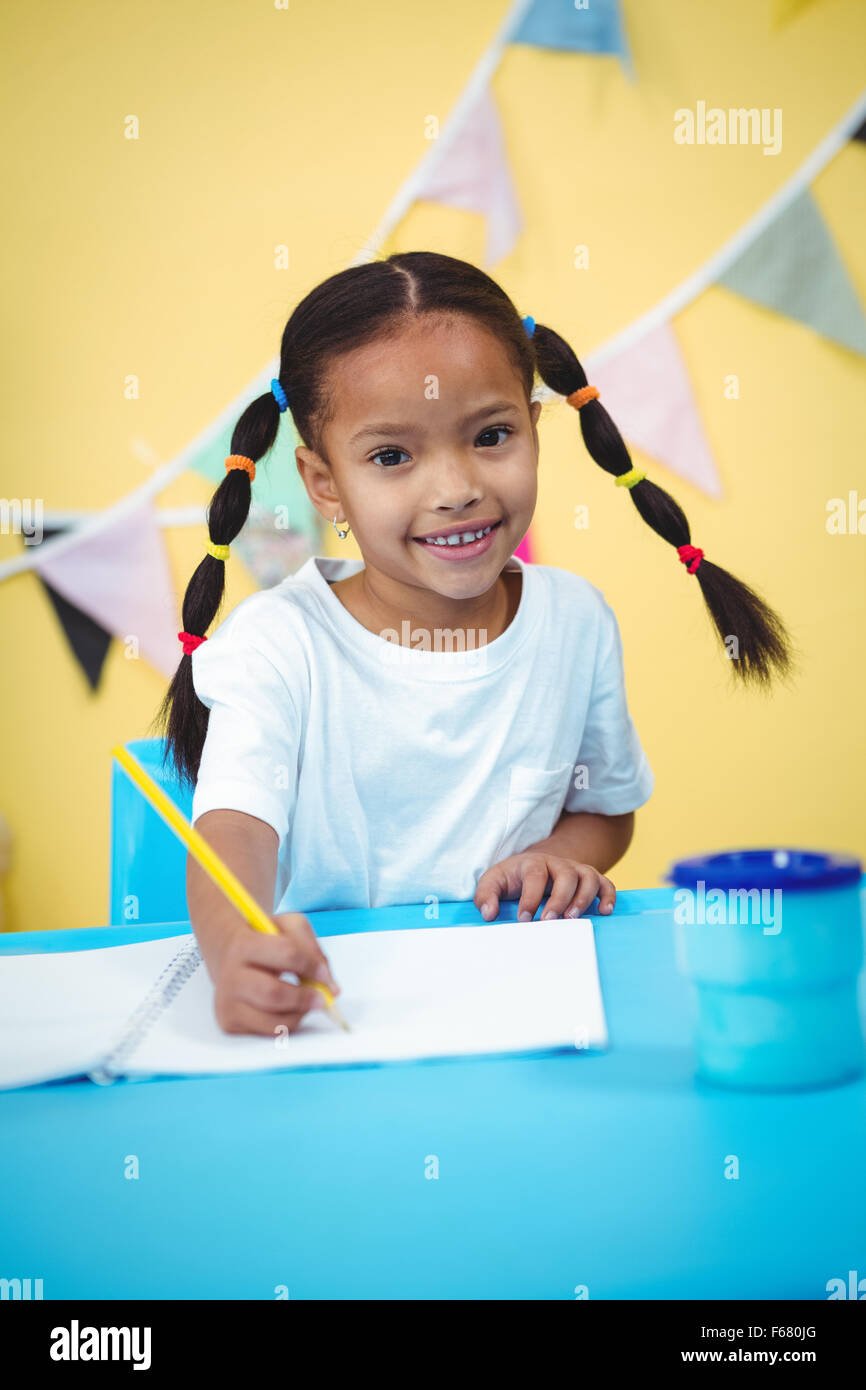Smiling girl drawing in her colouring book Stock Photo