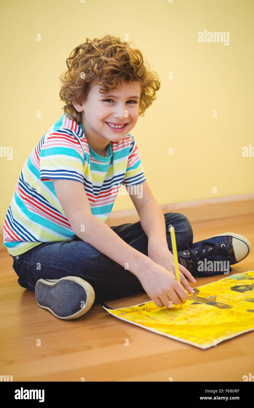 Smiling boy colouring some paper Stock Photo