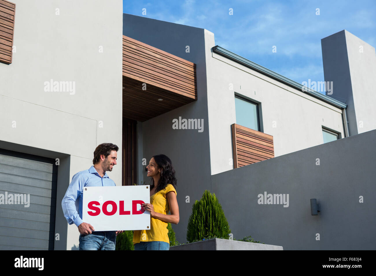 Happy couple in front of new house Stock Photo