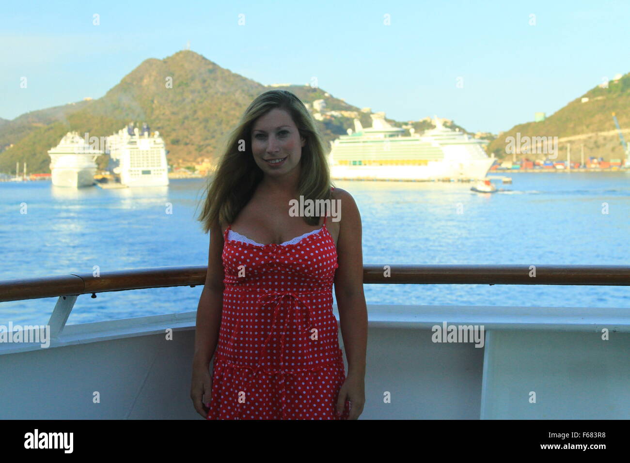 Young woman on a cruise ship with the  Dr. A. C. Wathey Cruise port and three cruise ships in the background. Stock Photo