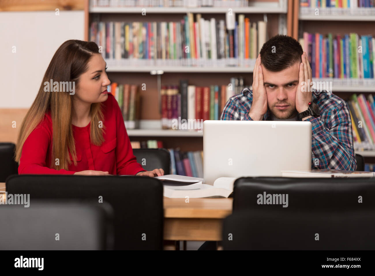 Stressed Students In High School Sitting At The Library Desk - Shallow Depth Of Field Stock Photo