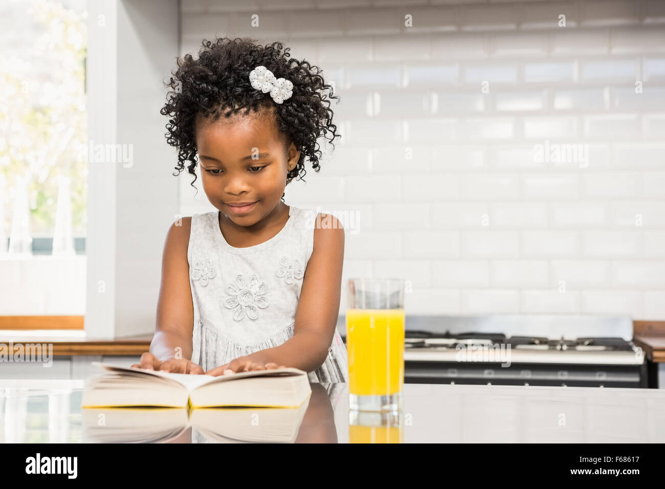 Smiling girl reading a book Stock Photo - Alamy