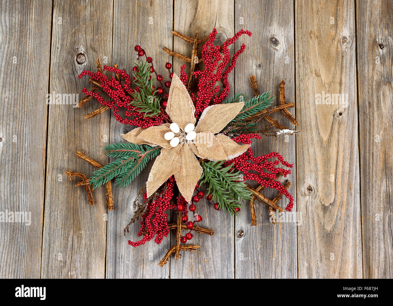 Holiday wreath, cloth flower in center, on rustic wood. Layout in horizontal format. Stock Photo