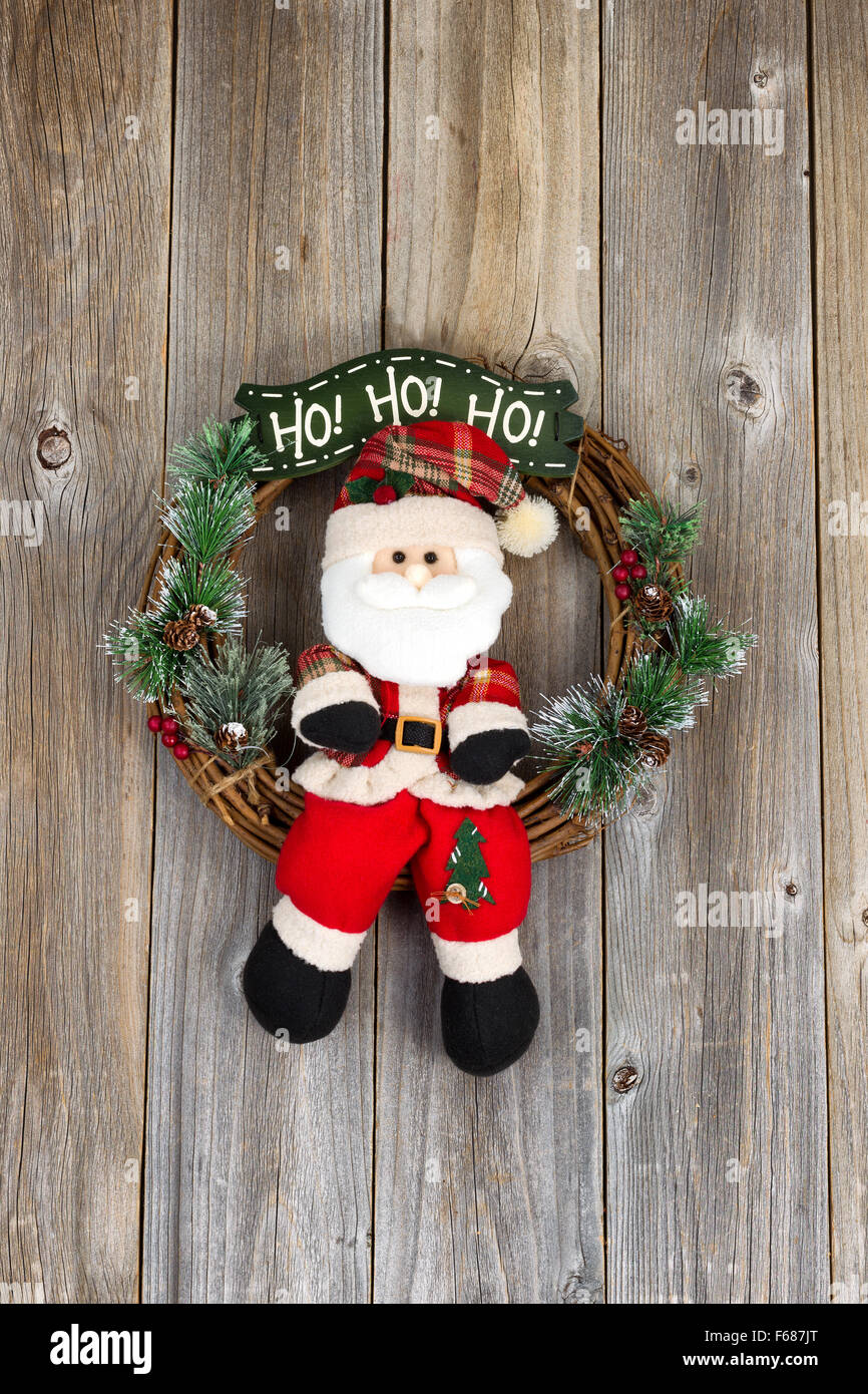 Wreath with Santa Claus symbol on rustic wood. Layout in vertical format. Stock Photo