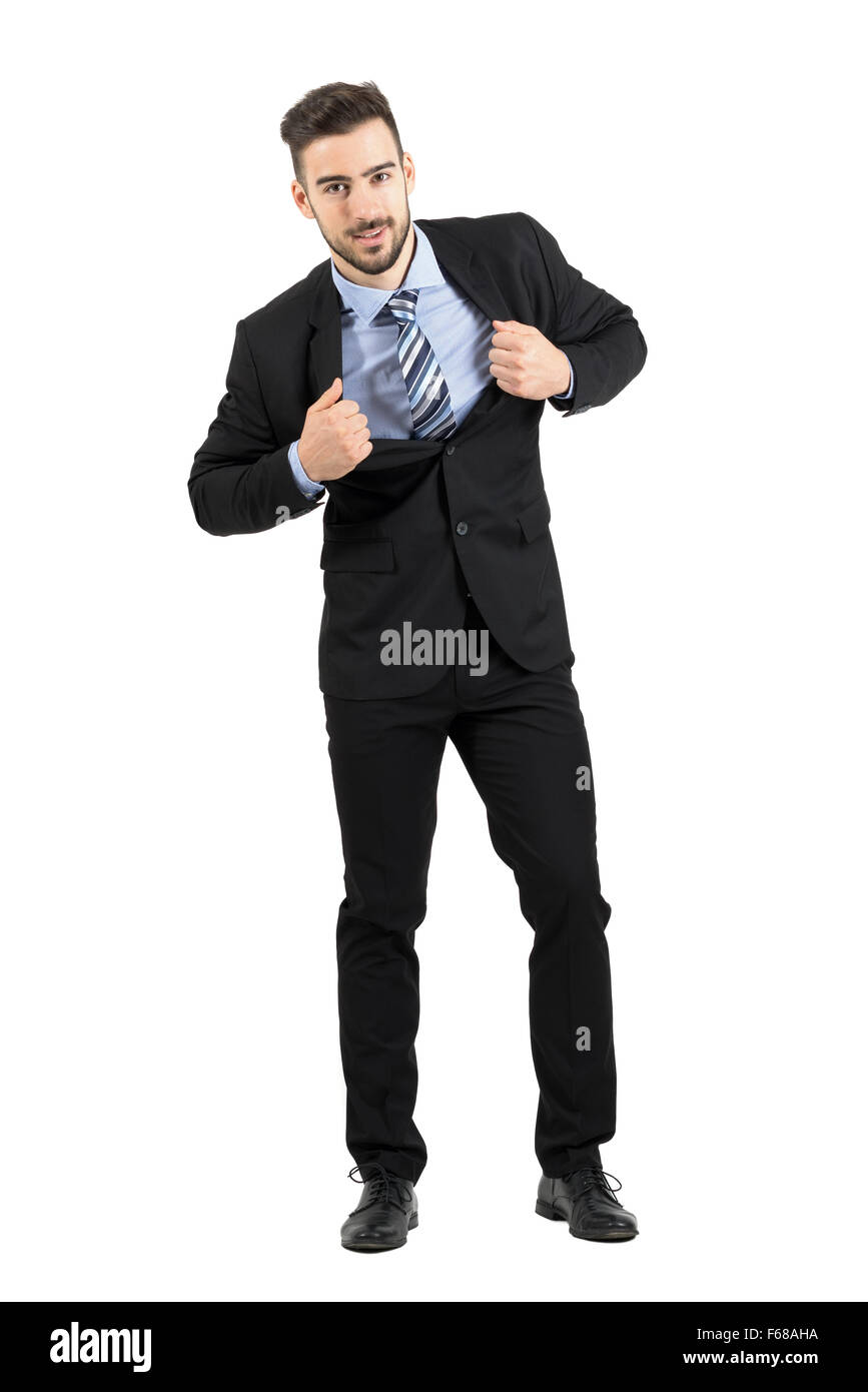 Young happy businessman pulling and stretching his suit jacket smiling at camera. Full body length portrait isolated over white Stock Photo