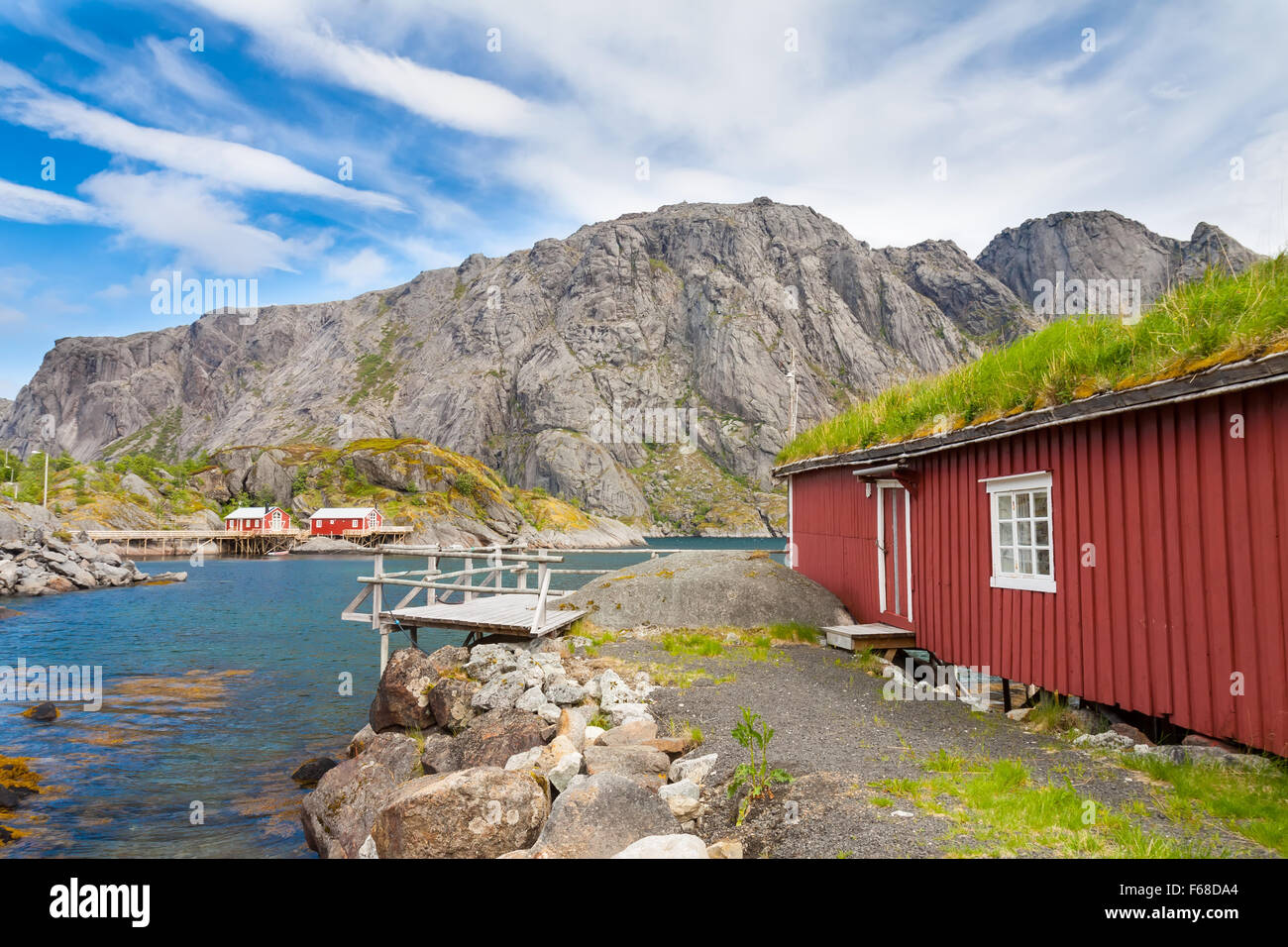 Typical red rorbu fishing hut in town of Svolvaer on Lofoten islands in Norway lit by midnight sun Stock Photo