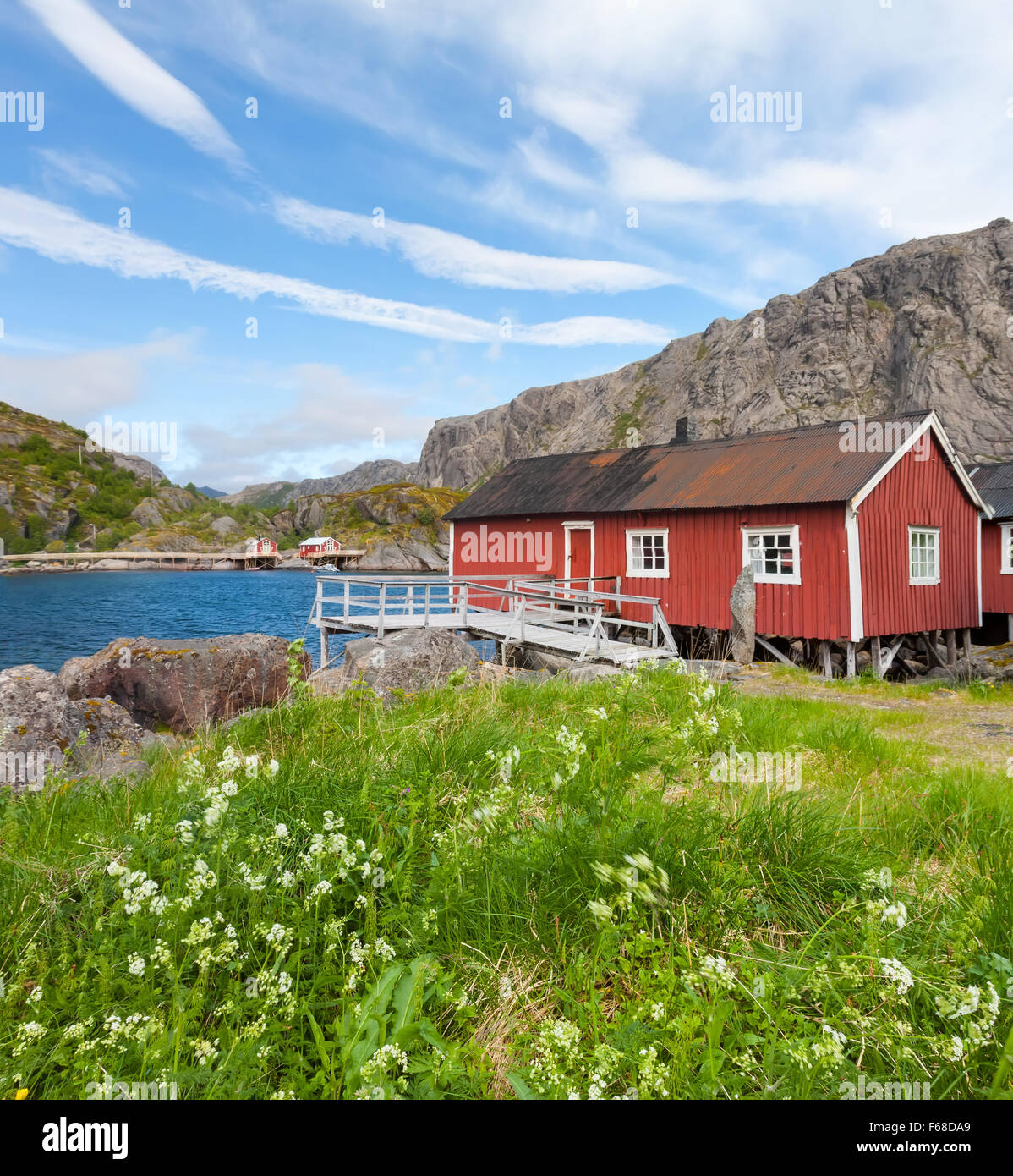 Typical red rorbu fishing hut in town of Svolvaer on Lofoten islands in Norway lit by midnight sun Stock Photo