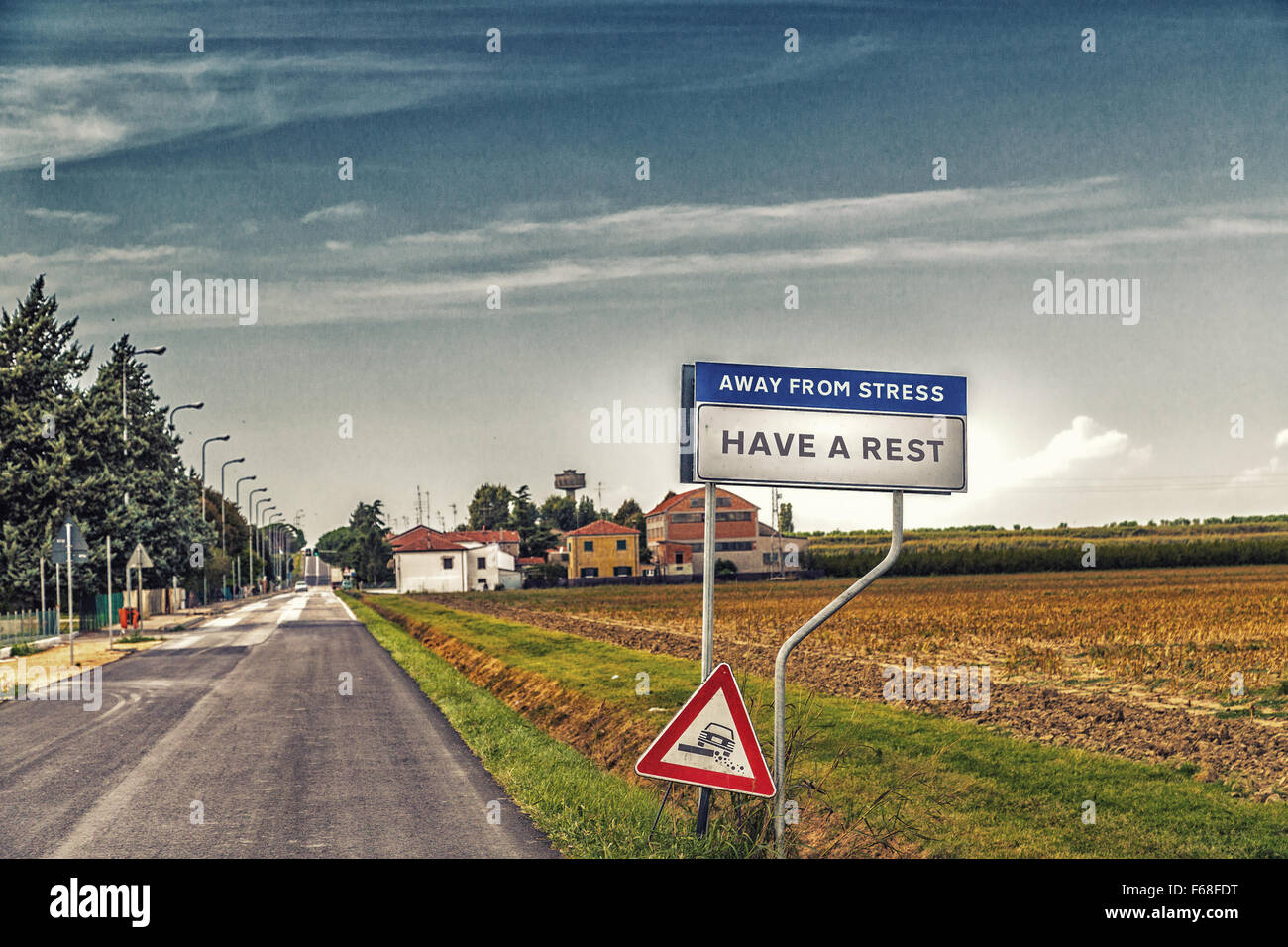 fake road sign of a quiet countryside village inviting to have a rest away from stress Stock Photo