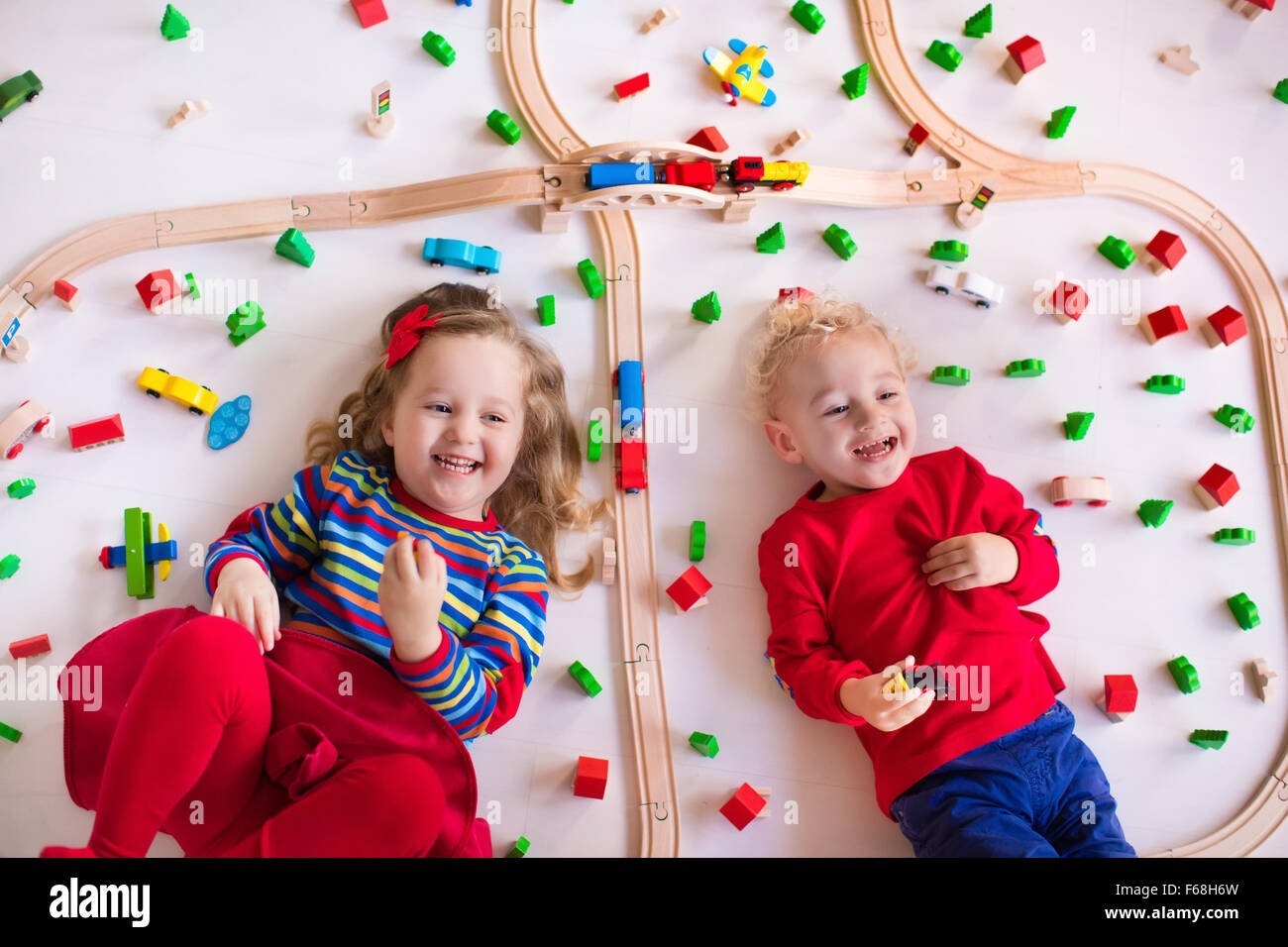 Children playing with wooden train. Toy railroad. Toddler kid and baby
