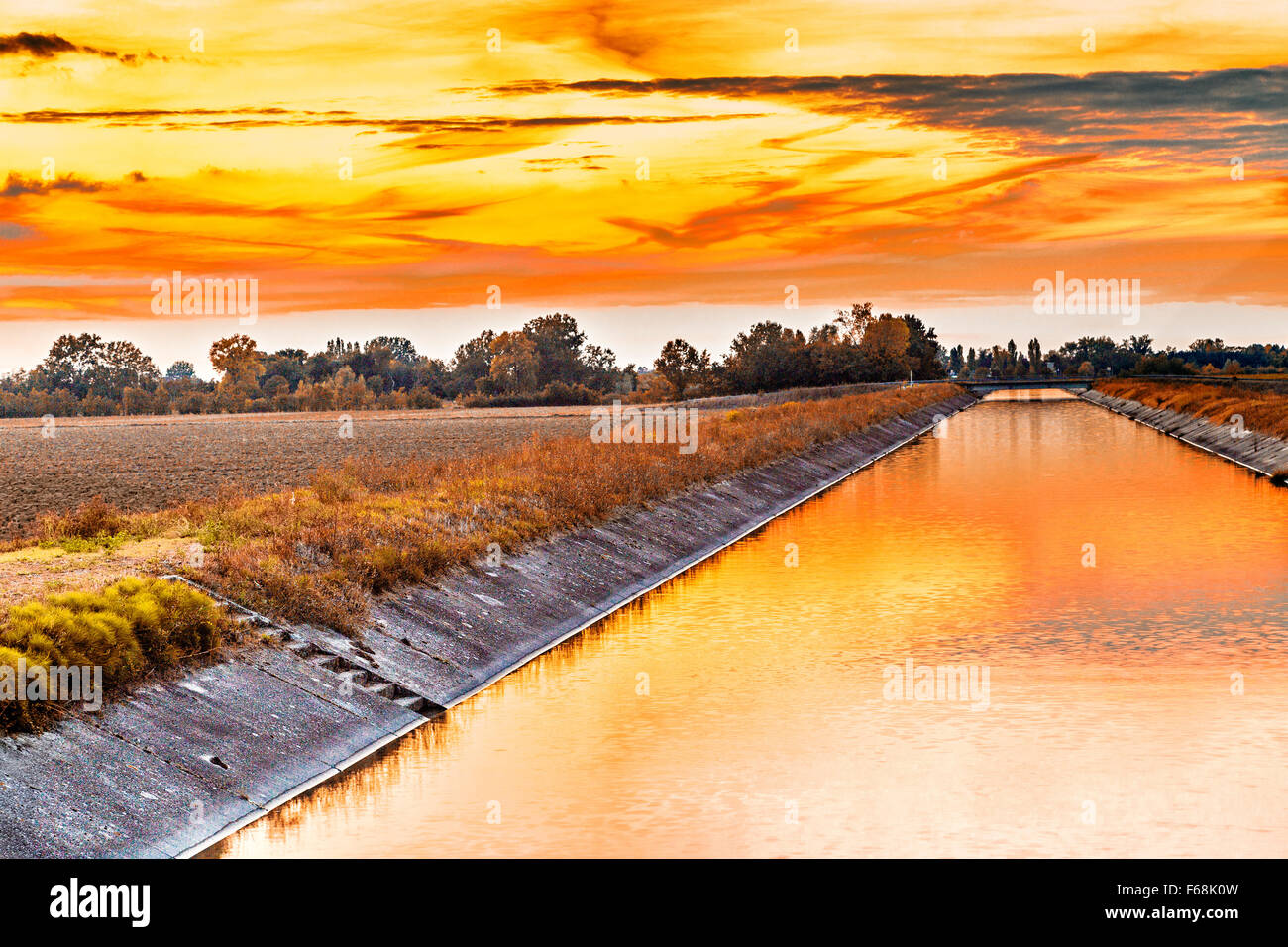 Channel to divert river water for irrigation of cultivated fields Stock Photo