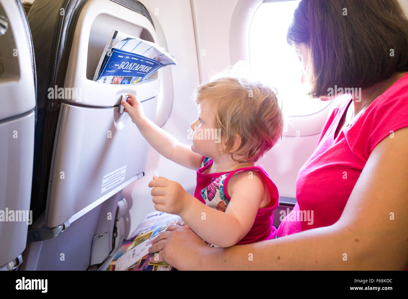 Mother travelling with one year old baby on an aeroplane Stock Photo