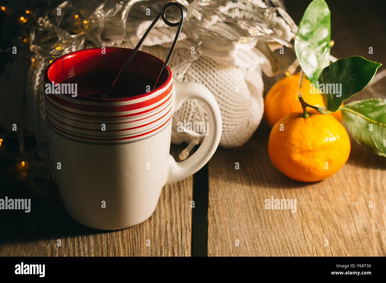 Cup of tea, pullover, tangerine in a low key selective focus Stock Photo