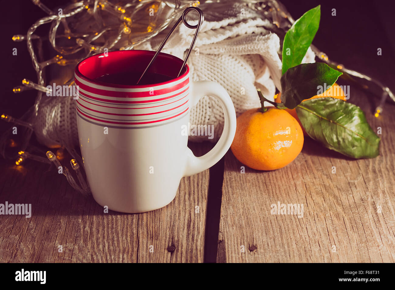 Cup of tea, pullover, tangerine in a low key selective focus low key Stock Photo