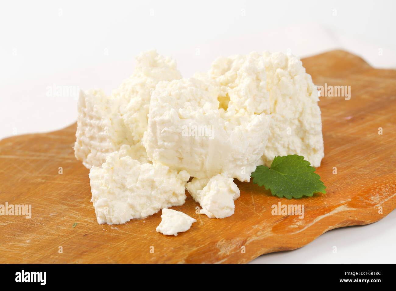 slices of fresh curd cheese on wooden cutting board Stock Photo