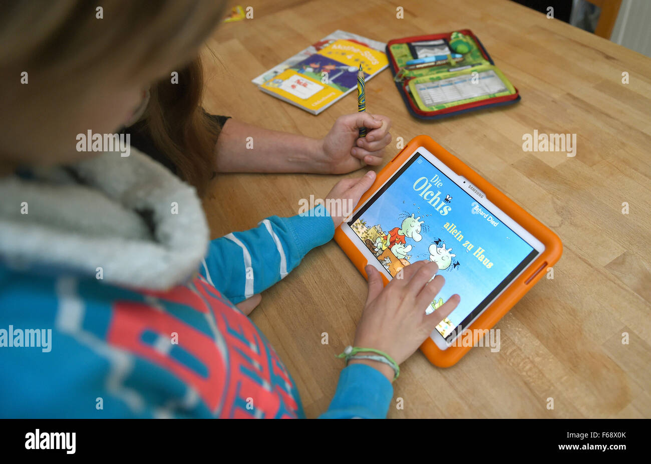 Oldenburg, Germany. 10th Nov, 2015. Ten-year-old Peeke plays the educational game 'Die Olchis' (The Olchis) on a tablet with his mother at their home in Oldenburg, Germany, 10 November 2015. Publishing companies are increasingly offering apps and educational games in addition to traditional storybooks. Photo: CARMEN JASPERSEN/dpa/Alamy Live News Stock Photo