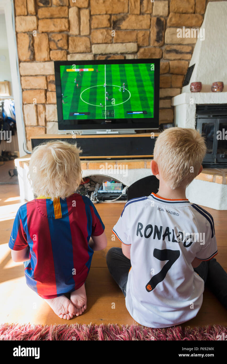 boys playing soccer game on TV Stock Photo