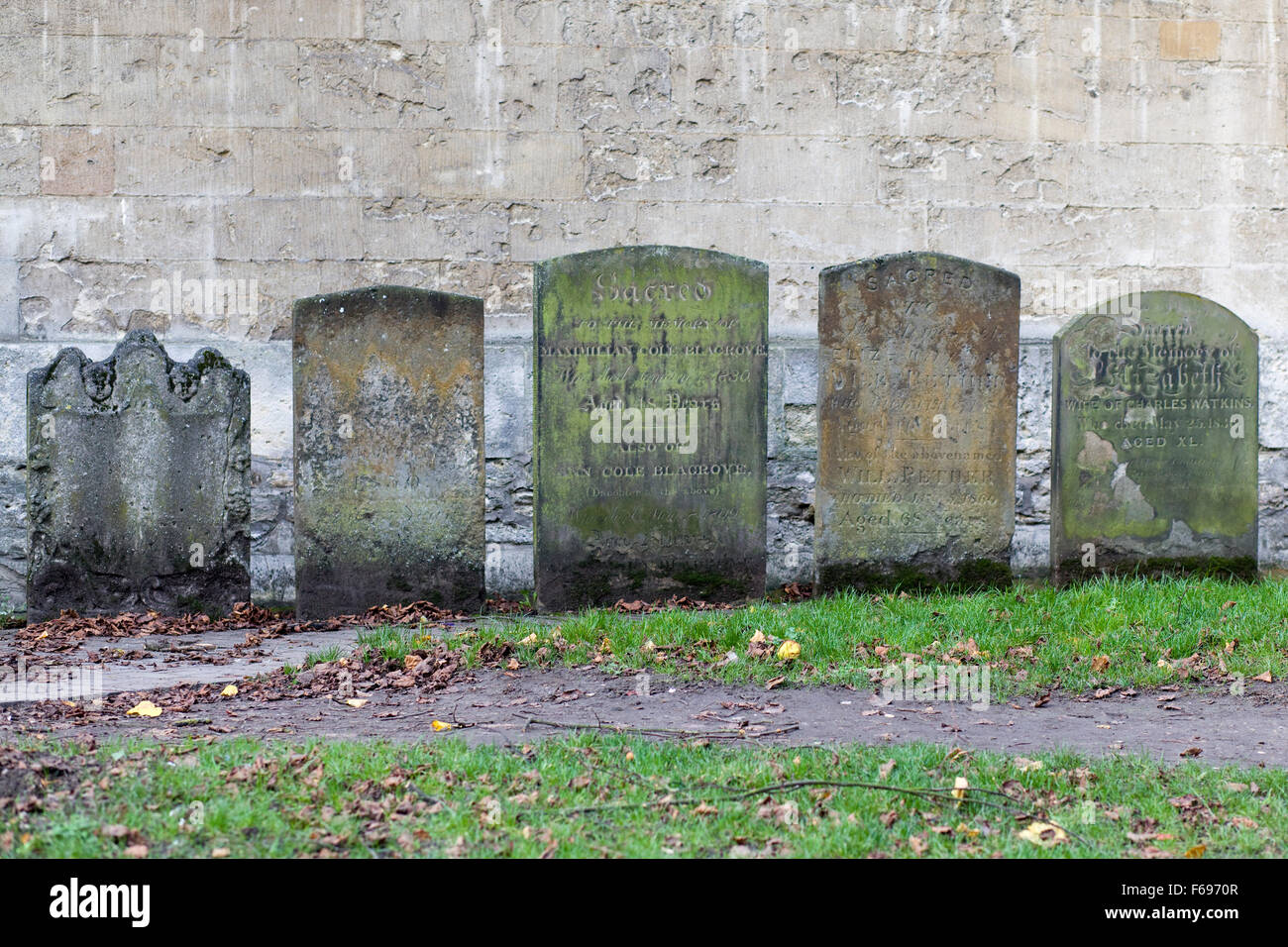 Grave stones against a stone wall Stock Photo Alamy