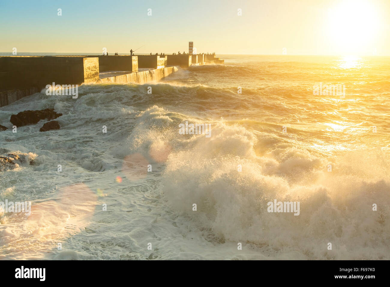 Ocean surf near the pier during a stunning sunset. Stock Photo