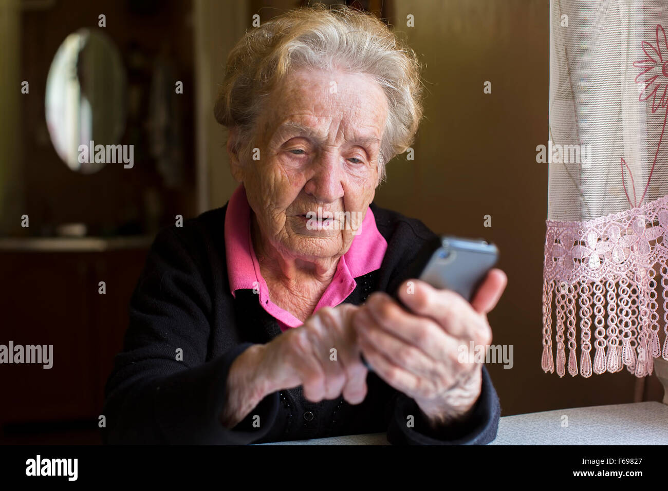 Elderly woman typing on the smartphone. Stock Photo