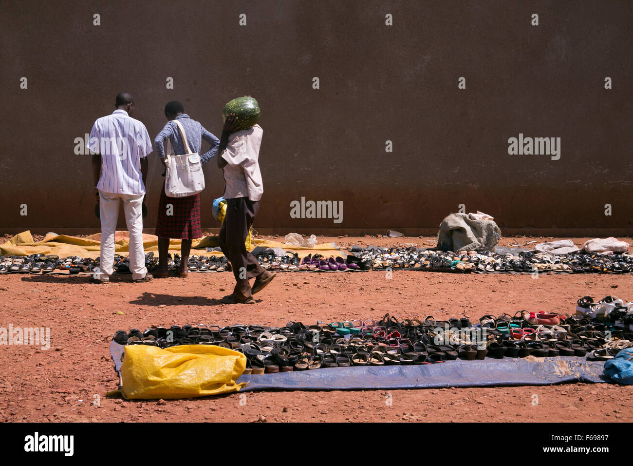 People look at shoes for sale in the outdoor market in Kayonza, Rwanda. Stock Photo
