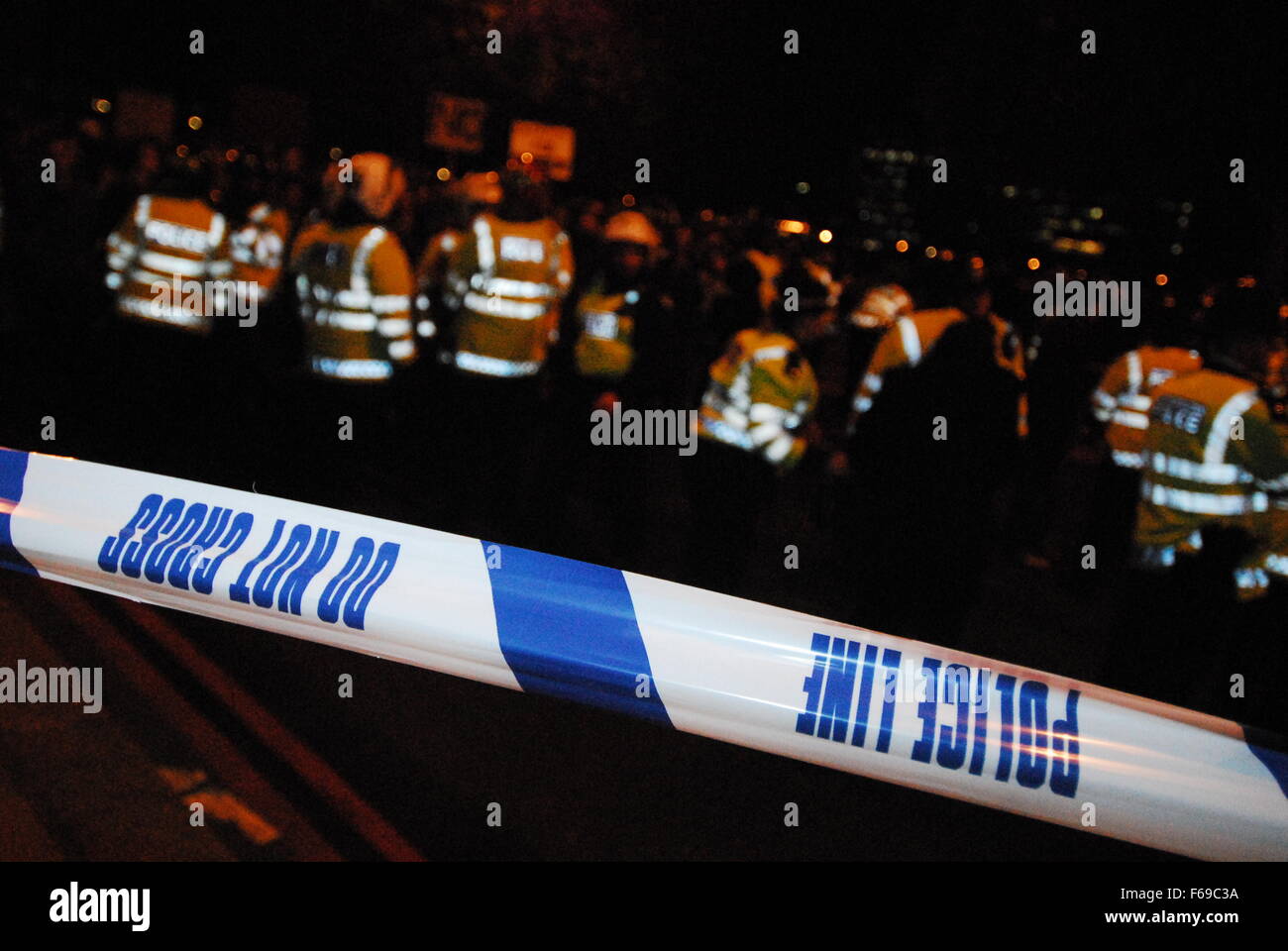 Police cordon tape behind a line of officers at a protest in London, UK in March 2011. Stock Photo