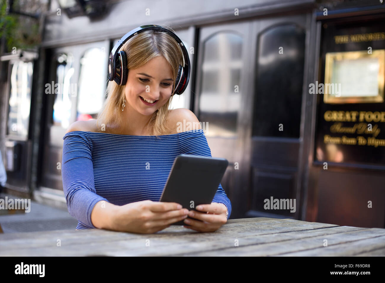 young woman an ereader and listening to music Stock Photo