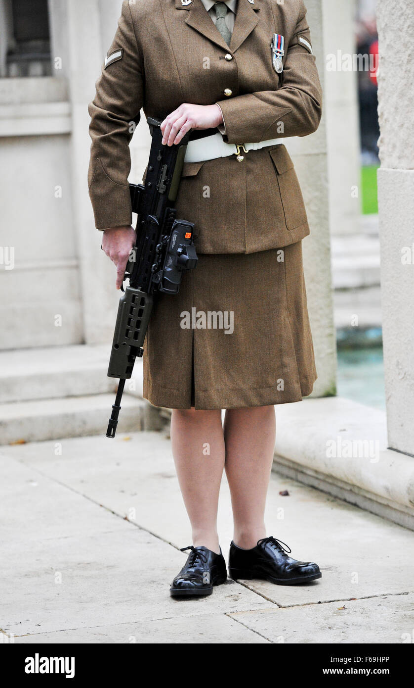 Female army soldier in British armed forces carrying a gun weapon Stock Photo