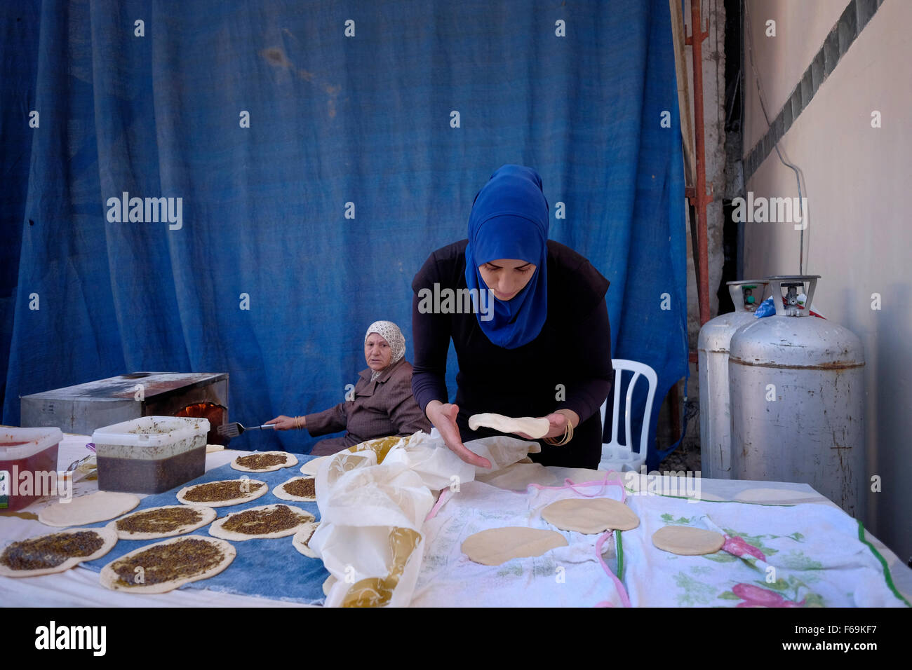 Israeli Arab women prepare traditional Pita bread spread with olive oil and Zaatar in the mixed