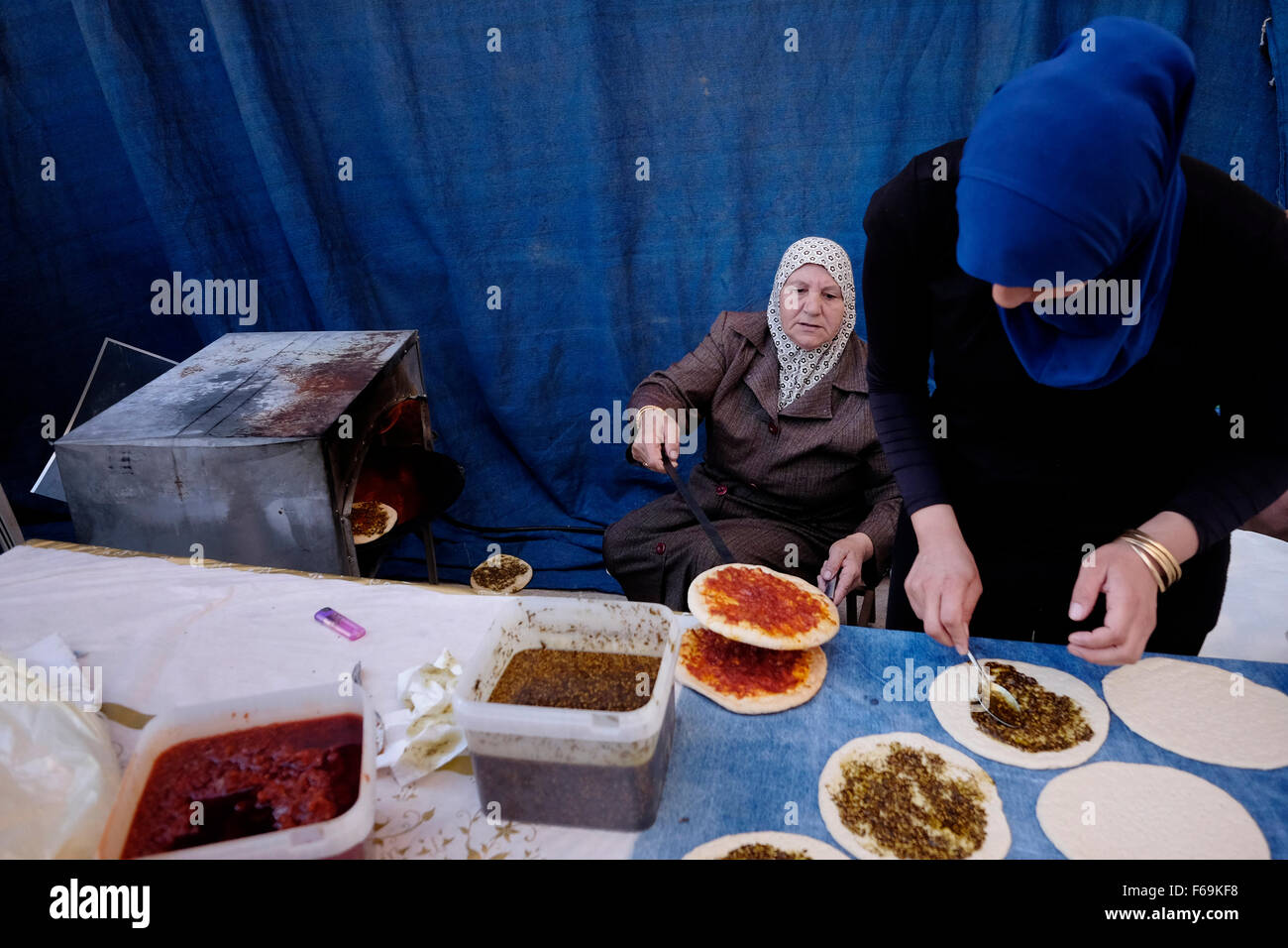 Arab women prepare traditional Pita bread spread with olive oil and Zaatar in the mixed Jewish