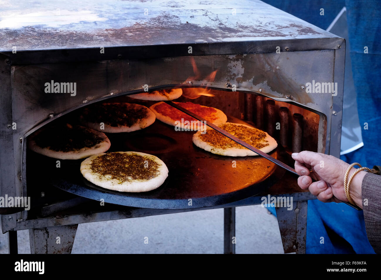 An Arab Israeli woman bakes traditional Pita bread spread with olive oil and Zaatar in the mixed