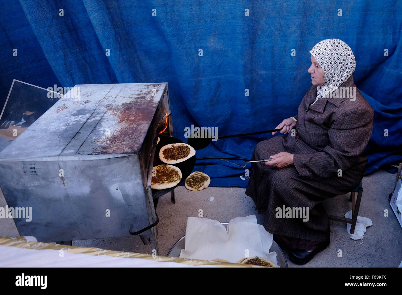 An Israeli Arab woman bakes traditional Pita bread spread with olive oil and Zaatar in the mixed