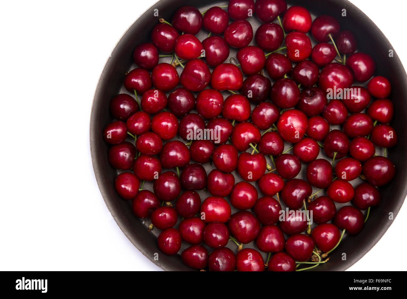 Red cherries in round baking tin, isolated on white background with copy-space for your text Stock Photo