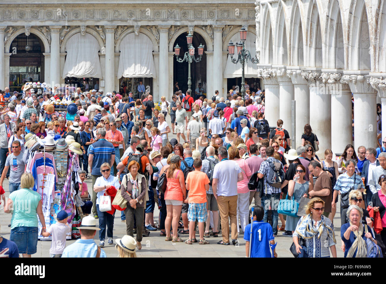 Venice crowd of tourist people at busy popular sightseeing visitor attraction on Riva degli Schiavoni promenade on a hot summers day in Veneto Italy Stock Photo
