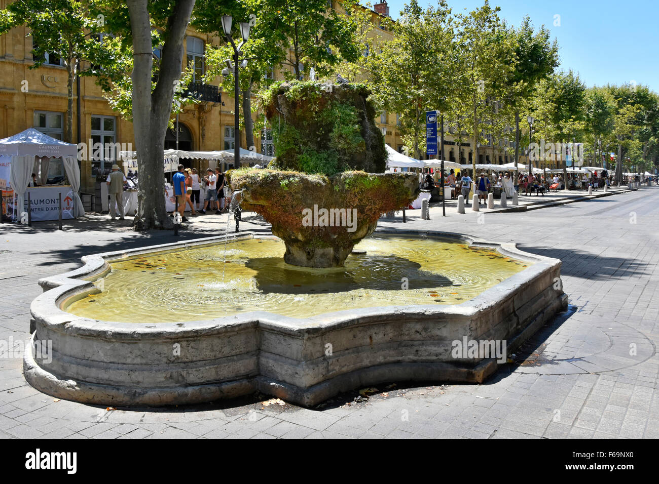 Aix en Provence South of France Cours Mirabeau boulevard and Fontaine des Neuf-Canons with all white Sunday street market beyond Stock Photo