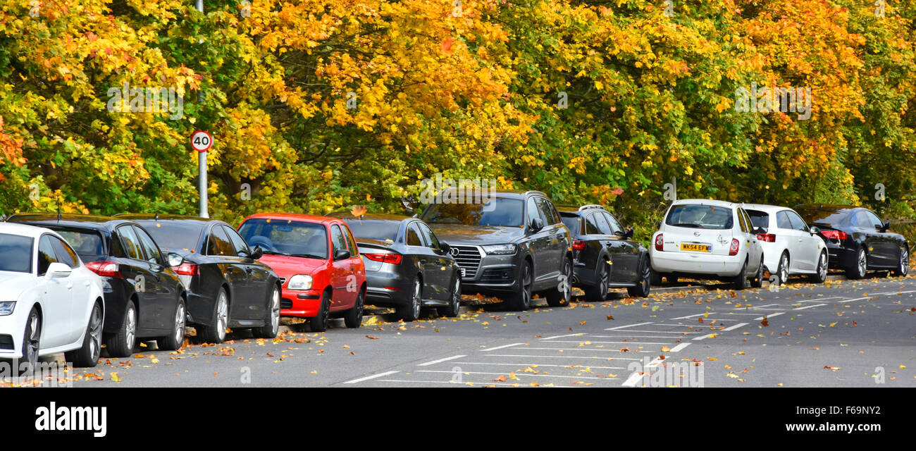 Cars parked over kerb on access road adjacent to modern industrial estate Essex England UK Stock Photo
