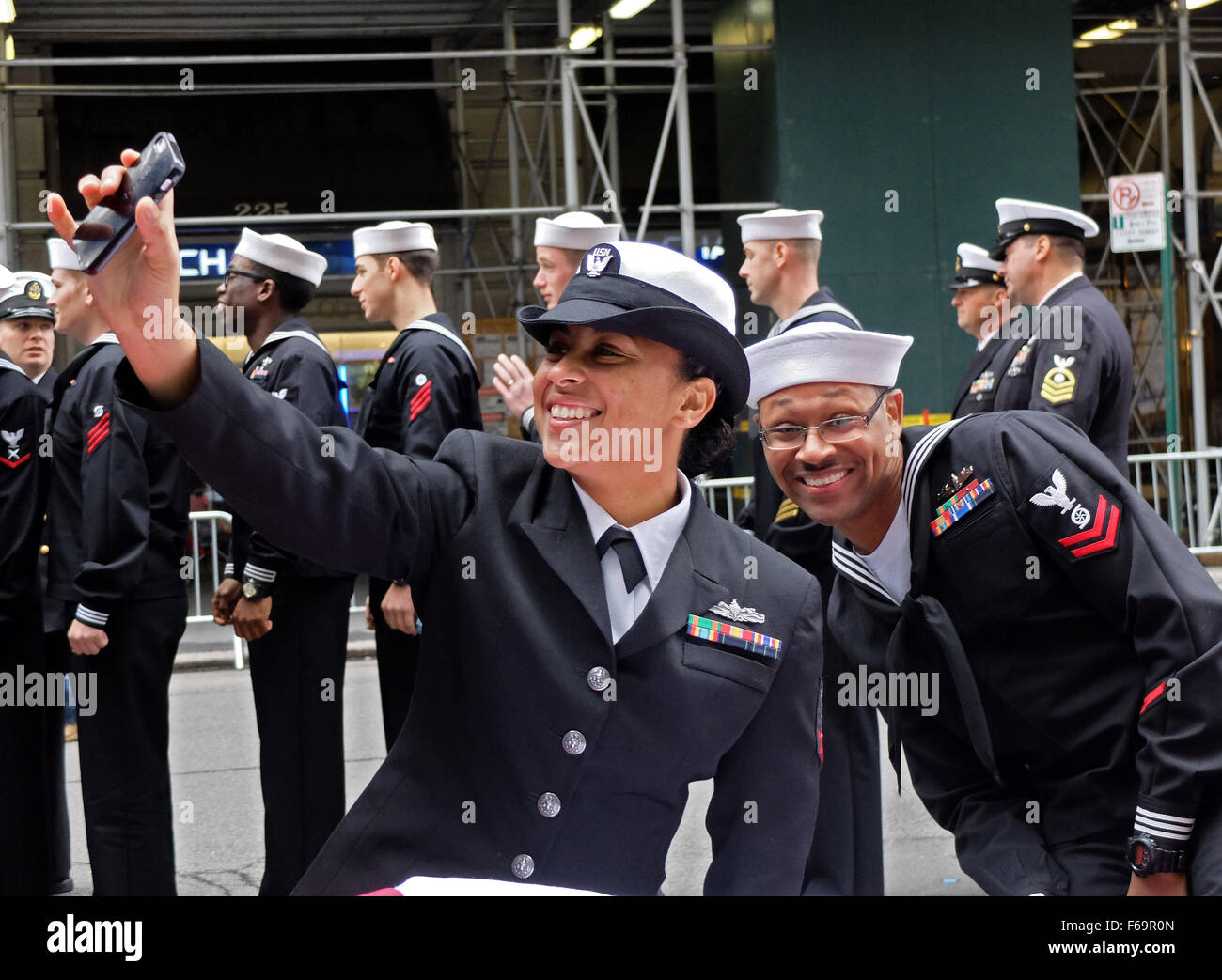 In New York City, a woman in the Navy takes a selfie prior to the Veteran's Day parade and gets photo bombed. Stock Photo