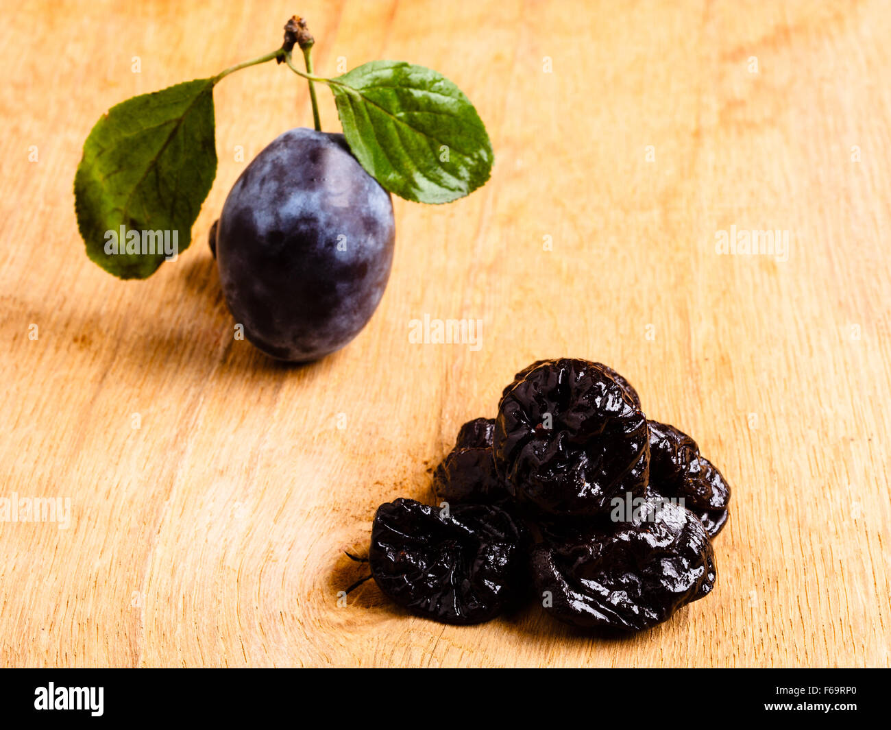 Healthy food, good cuisine. Closeup dried plums and fresh prune fruit on wooden rustic table Stock Photo